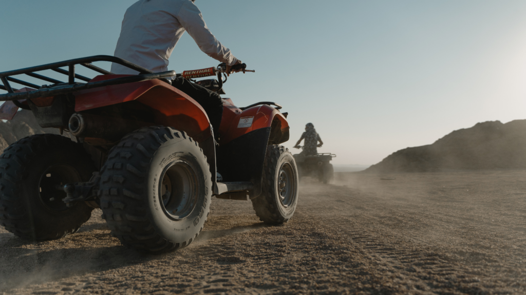 a group of people riding atvs in the sand