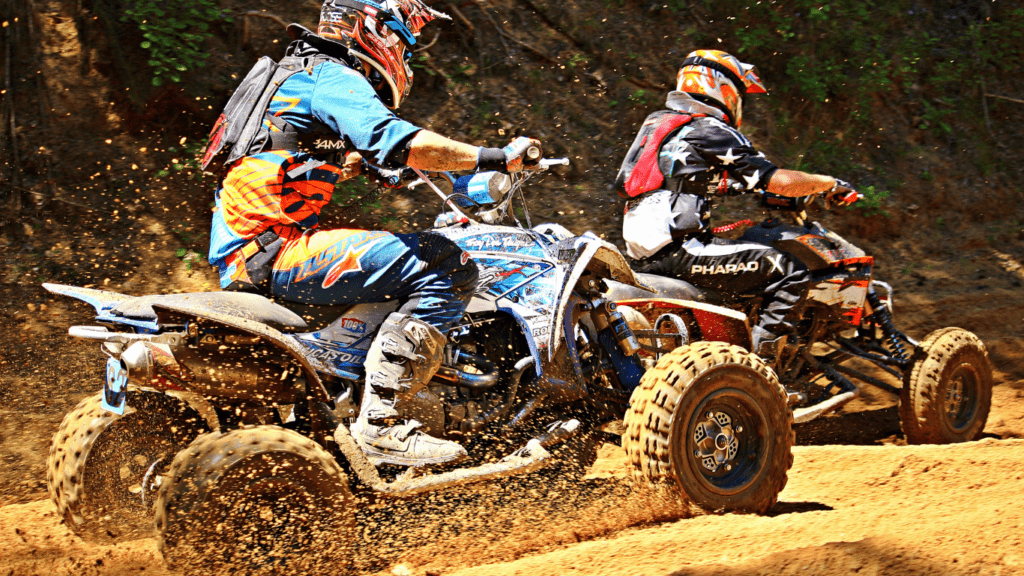 two people riding ATVs on a dirt trail