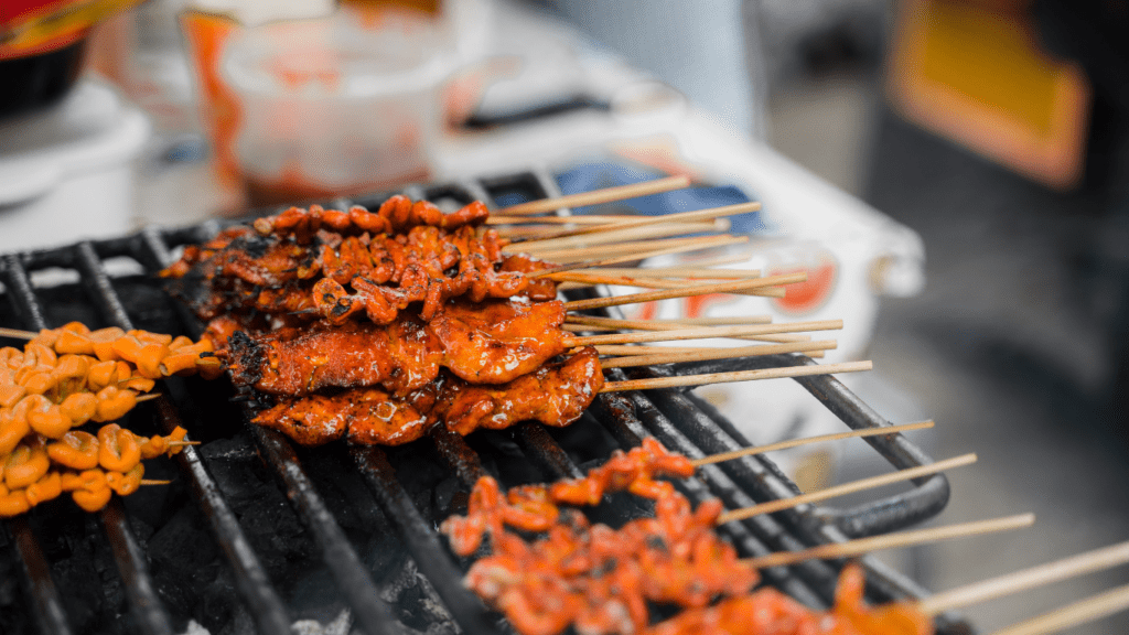 a person is preparing food on skewers at a food stand