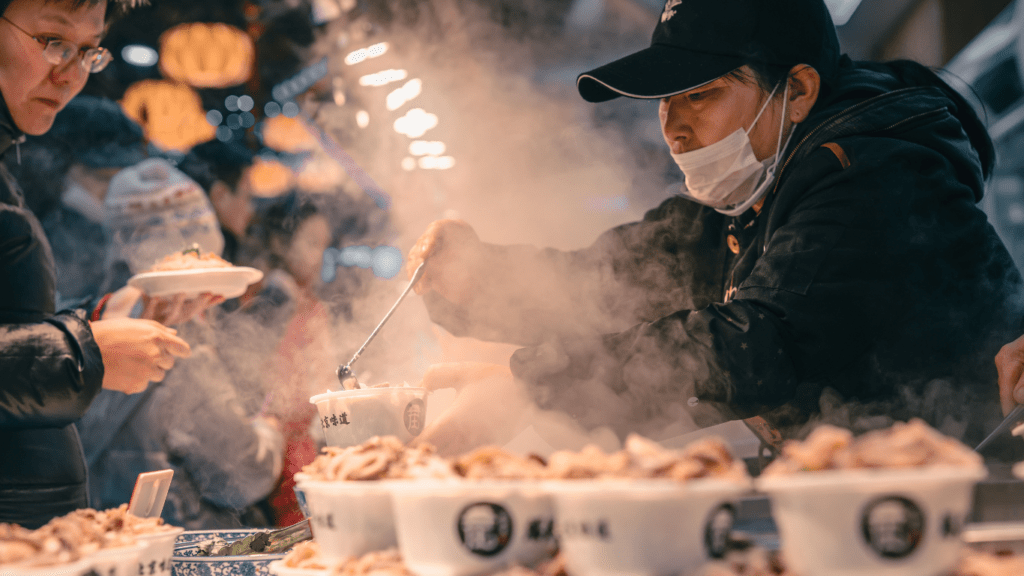 a person selling food on the street at night