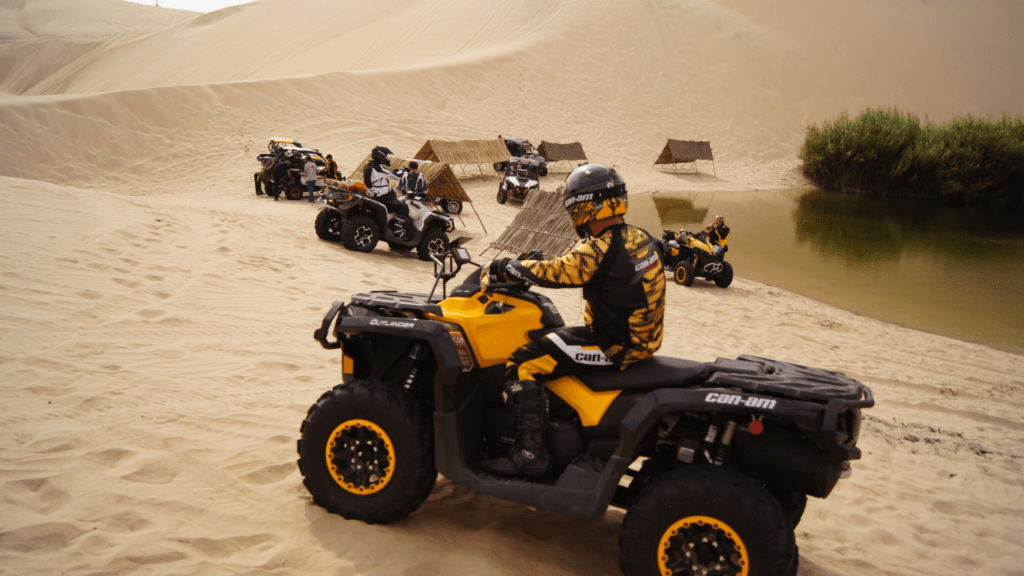 a group of people riding atvs in the sand