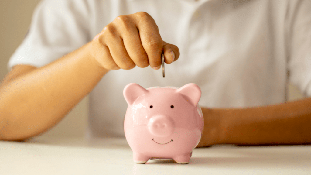 a person putting a coins in a piggy bank