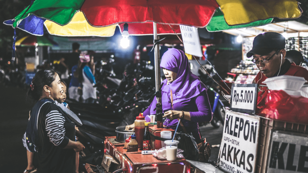 a person selling food on the street at night